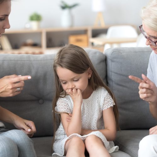 Angry mother and grandmother scolding lecturing upset kid girl together, strict young mom and old grandma talking to child reprimanding  demanding discipline, three generations upbringing concept